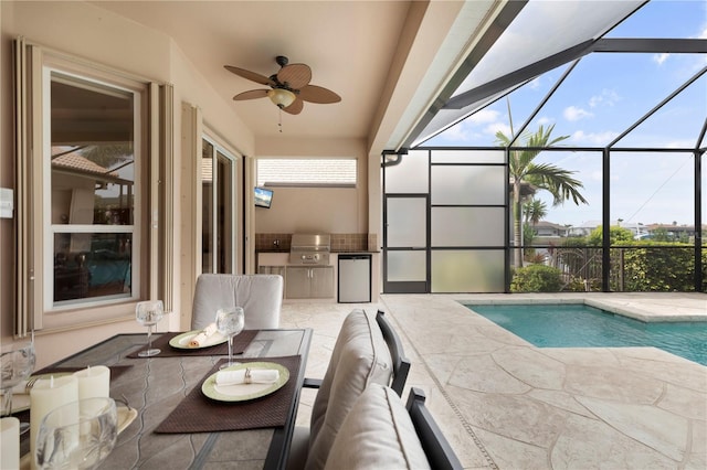 view of swimming pool featuring a grill, a patio, ceiling fan, and exterior kitchen