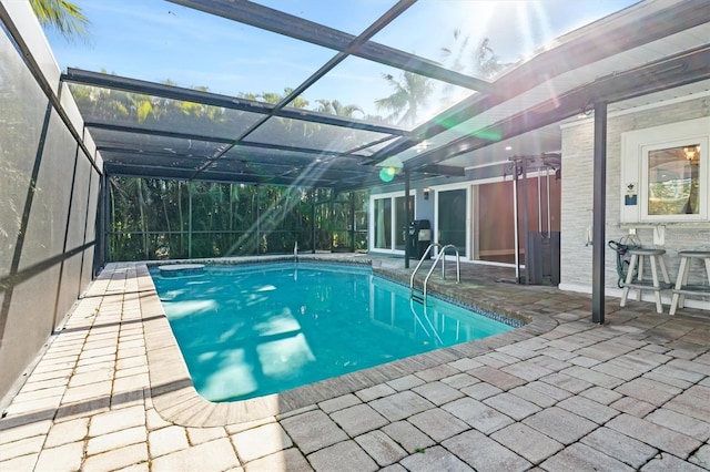 view of swimming pool featuring a patio and a lanai