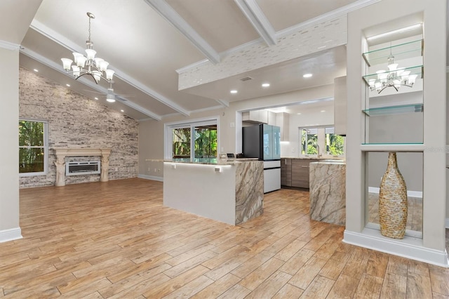 kitchen featuring a fireplace, light wood-type flooring, white fridge, and a wealth of natural light