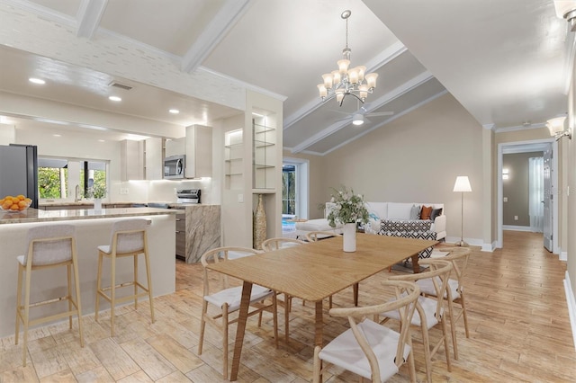 dining space with vaulted ceiling with beams, ornamental molding, ceiling fan with notable chandelier, and light wood-type flooring