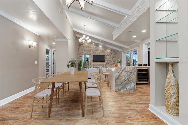 dining area with a notable chandelier, a healthy amount of sunlight, light hardwood / wood-style floors, and a fireplace