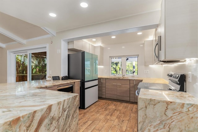 kitchen with crown molding, sink, stainless steel appliances, and light hardwood / wood-style flooring