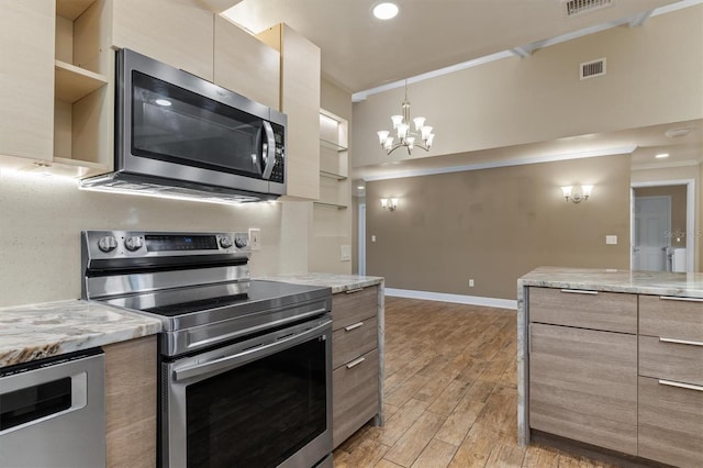 kitchen featuring light hardwood / wood-style floors, light stone counters, ornamental molding, and appliances with stainless steel finishes