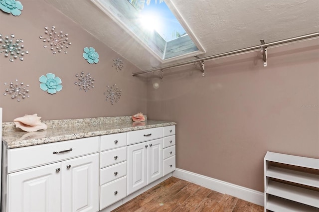 bathroom featuring hardwood / wood-style flooring, vanity, and a skylight