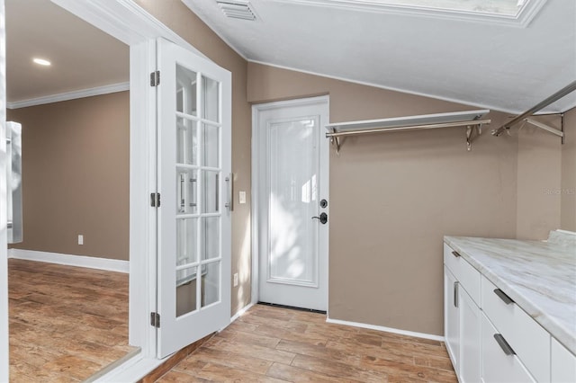 clothes washing area featuring light hardwood / wood-style floors and ornamental molding