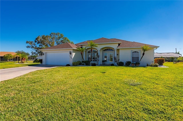 mediterranean / spanish-style house featuring a front lawn, a garage, and french doors