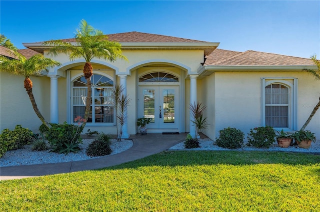 property entrance featuring a yard and french doors