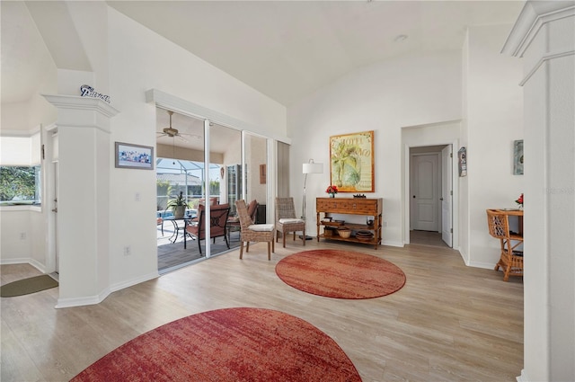 living area with ceiling fan, lofted ceiling, and light hardwood / wood-style flooring