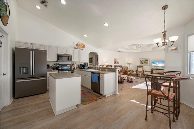 kitchen featuring stainless steel appliances, kitchen peninsula, light hardwood / wood-style floors, decorative light fixtures, and ceiling fan with notable chandelier