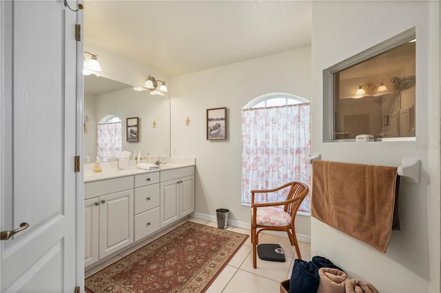 bathroom with tile patterned flooring, a shower, and vanity