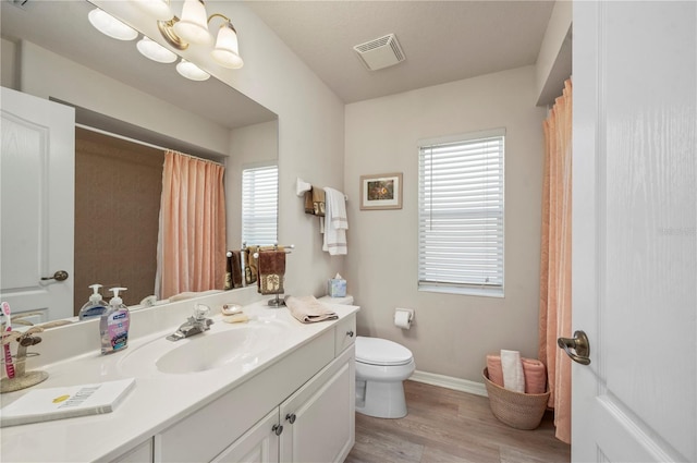 bathroom featuring a chandelier, hardwood / wood-style floors, vanity, and toilet