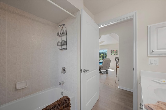 bathroom with hardwood / wood-style floors, vanity, and tiled shower / bath combo