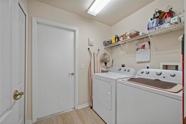 laundry area with washer and dryer and light hardwood / wood-style floors