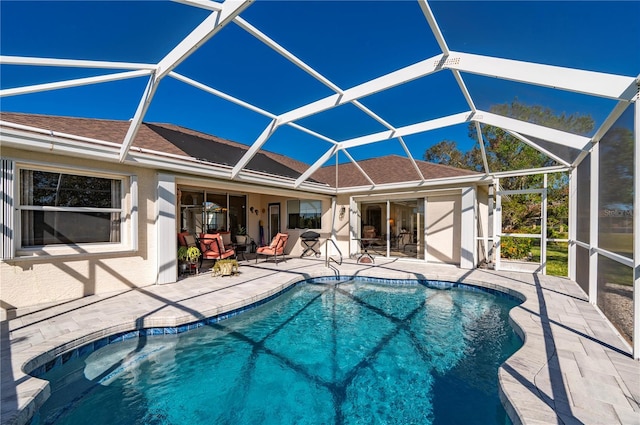 view of pool featuring glass enclosure and a patio area