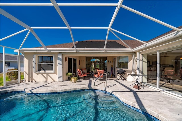 view of pool featuring outdoor lounge area, a patio, and glass enclosure