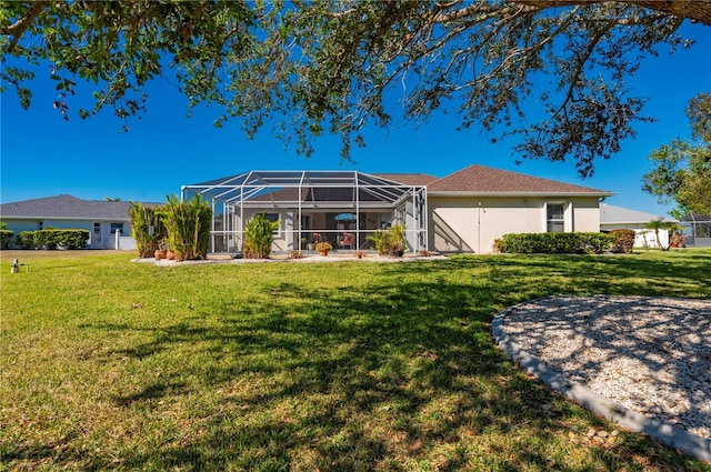 rear view of house with a lawn and a lanai