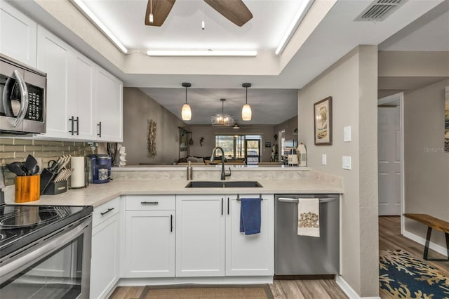 kitchen featuring sink, white cabinets, stainless steel appliances, and light hardwood / wood-style floors