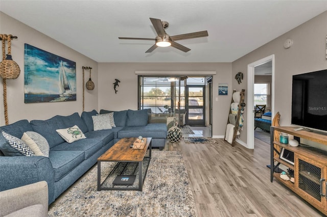 living room featuring light hardwood / wood-style flooring and ceiling fan