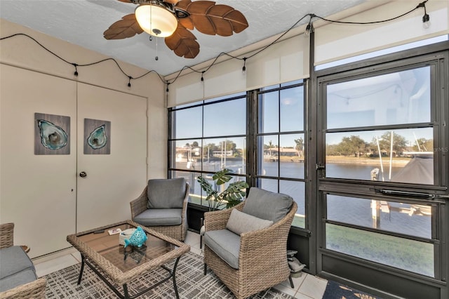 interior space with ceiling fan and a water view