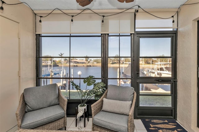 sunroom / solarium featuring a water view, ceiling fan, and a healthy amount of sunlight