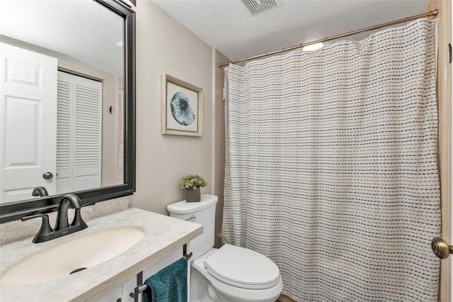 bathroom with walk in shower, vanity, a textured ceiling, and toilet