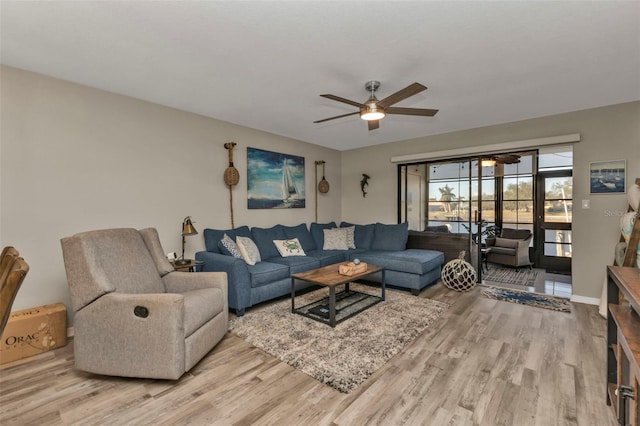 living room featuring wood finished floors, baseboards, and ceiling fan