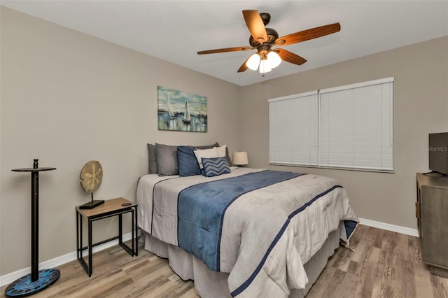 bedroom with baseboards, wood finished floors, and a ceiling fan