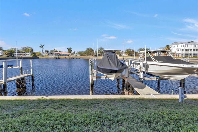 view of dock featuring a water view, boat lift, and a lawn