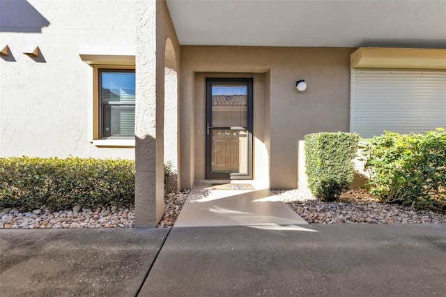 view of exterior entry featuring stucco siding