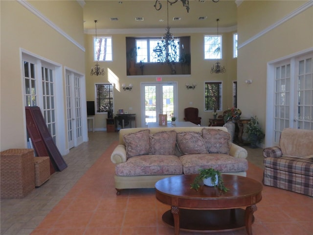 tiled living room with a high ceiling, a chandelier, and french doors