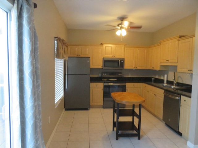 kitchen featuring ceiling fan, sink, light tile patterned floors, and black appliances