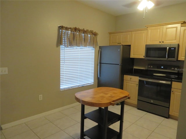 kitchen with ceiling fan, light tile patterned floors, refrigerator, and electric range