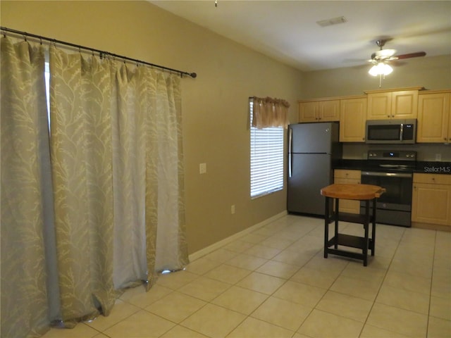 kitchen with light brown cabinetry, ceiling fan, fridge, electric range, and light tile patterned floors