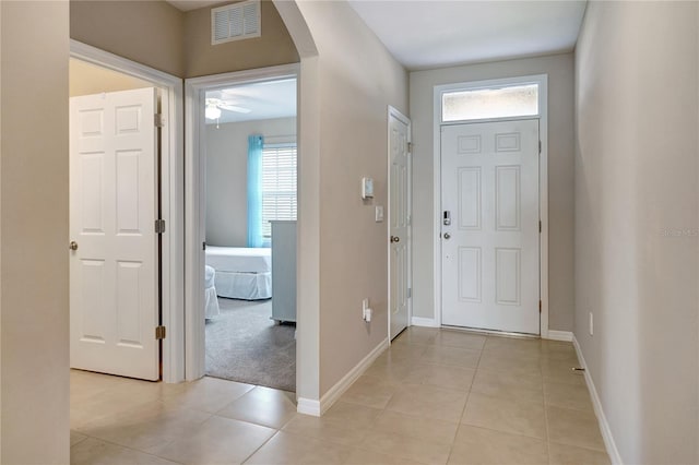 entryway featuring a wealth of natural light, light tile patterned flooring, and ceiling fan