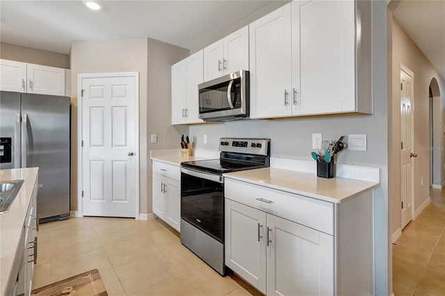 kitchen with white cabinets, light tile patterned flooring, and appliances with stainless steel finishes