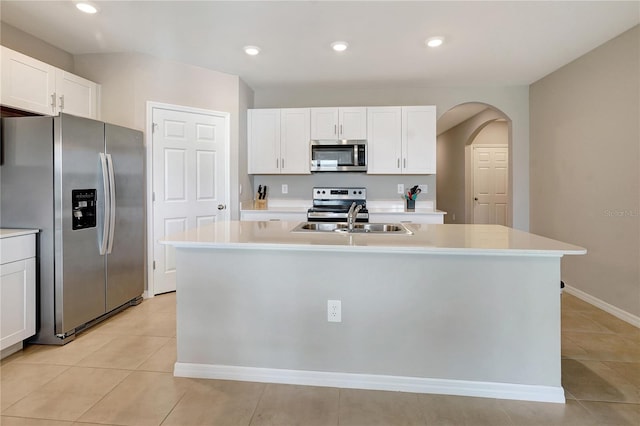 kitchen featuring appliances with stainless steel finishes, white cabinetry, a kitchen island with sink, and sink