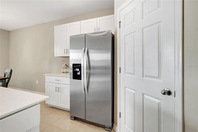 kitchen featuring stainless steel fridge with ice dispenser, white cabinetry, and light tile patterned flooring