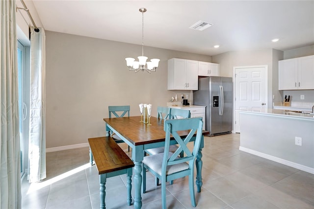 dining area featuring light tile patterned floors and an inviting chandelier