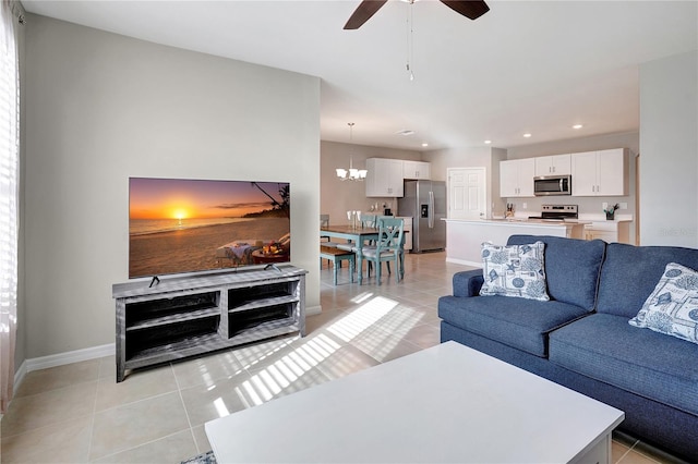 living room featuring ceiling fan with notable chandelier and light tile patterned flooring