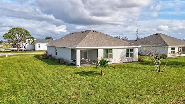 back of property featuring a lawn and a sunroom