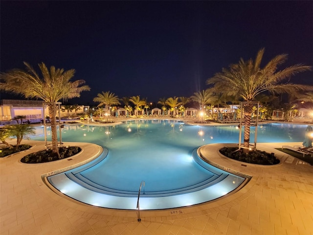 pool at twilight featuring a patio