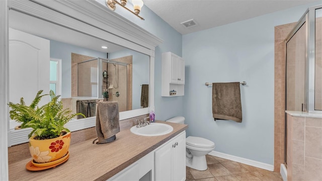 bathroom featuring tile patterned floors, vanity, an enclosed shower, and toilet