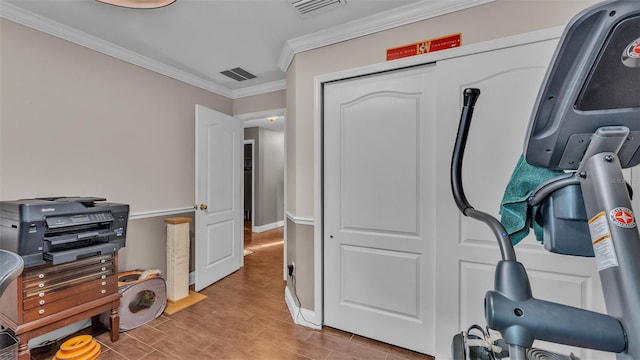 workout room featuring light hardwood / wood-style floors and ornamental molding