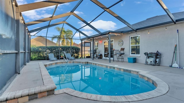 view of swimming pool featuring glass enclosure, area for grilling, and a patio area