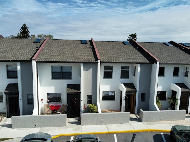 2000 Forrest Nelson Blvd Unit C8, Port Charlotte, FL 33952 - view of property featuring roof with shingles, stucco siding, and uncovered parking