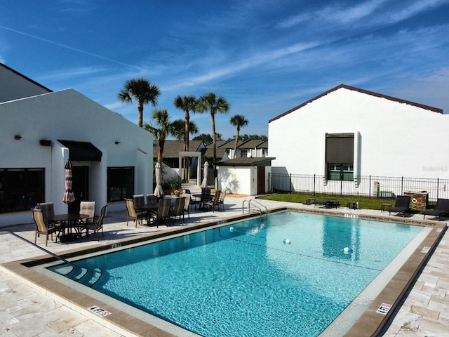 view of pool featuring a storage unit and a patio area