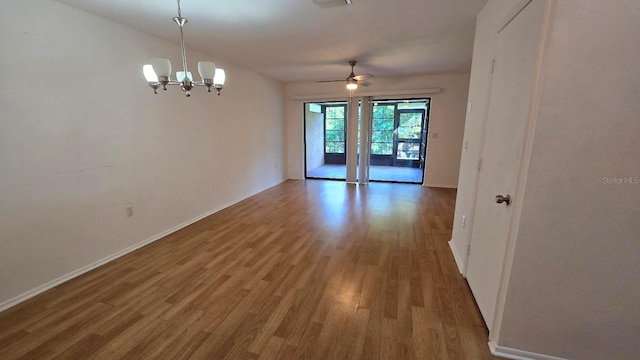 2000 Forrest Nelson Blvd Unit C8, Port Charlotte, FL 33952 - spare room featuring wood finished floors, a ceiling fan, a chandelier, and baseboards