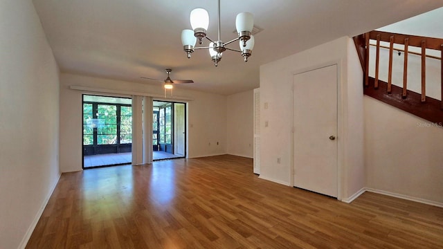 spare room featuring hardwood / wood-style flooring and ceiling fan with notable chandelier