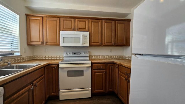 kitchen featuring white appliances and sink