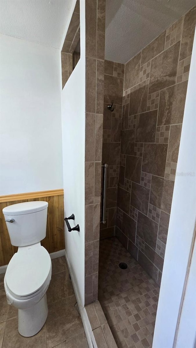 2000 Forrest Nelson Blvd Unit C8, Port Charlotte, FL 33952 - full bathroom featuring a shower stall, a textured ceiling, toilet, and wainscoting
